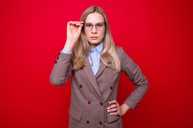 Portrait of a young woman in business clothes on a red background