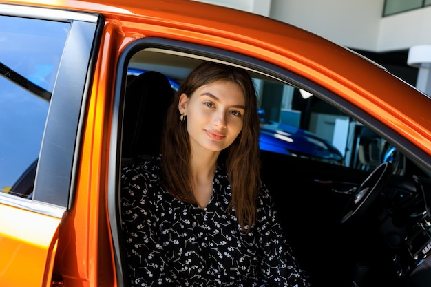 Portrait of a young woman in a car Buying a new car at a dealership