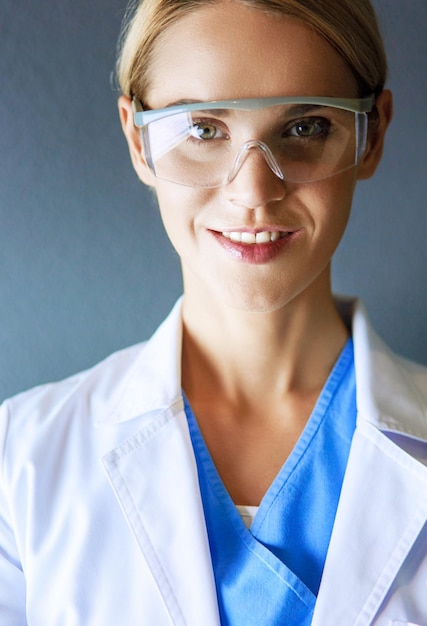 Portrait of young woman doctor with white coat standing in hospital