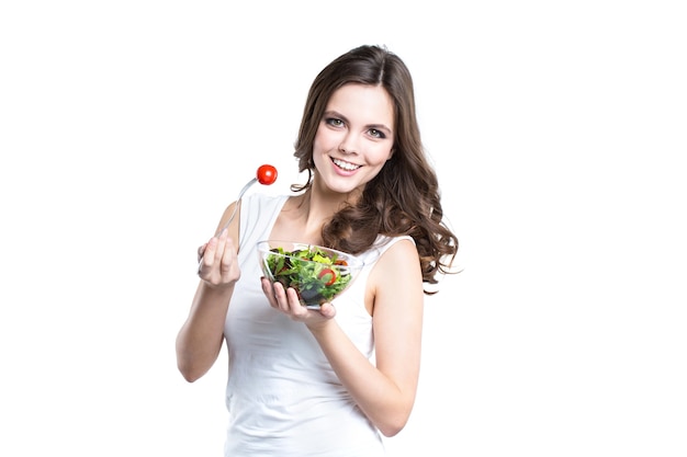 Portrait of young woman eating salad isolated. Concept of nutrition and a healthy lifestyle.