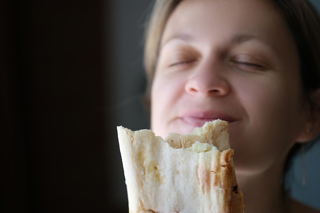 Portrait of young woman eating tasty shawarma yummy snack street food fastfood and food to go