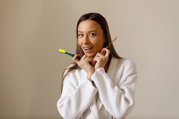 Portrait of young woman engaged in everyday procedures after shower Brushing your teeth with toothbrush Snowwhite smile Care beauty and health