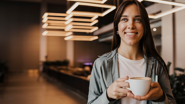 Portrait of a young woman enjoying coffee