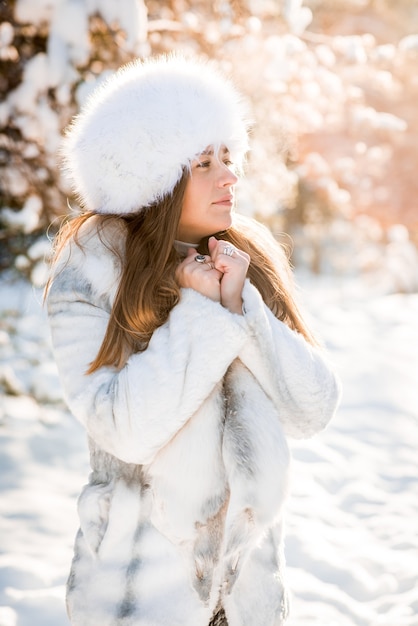 Portrait of young woman in the frosty winter forest