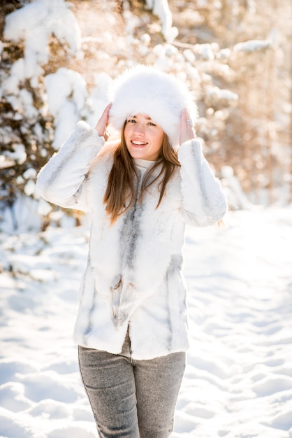 Portrait of young woman in the frosty winter forest