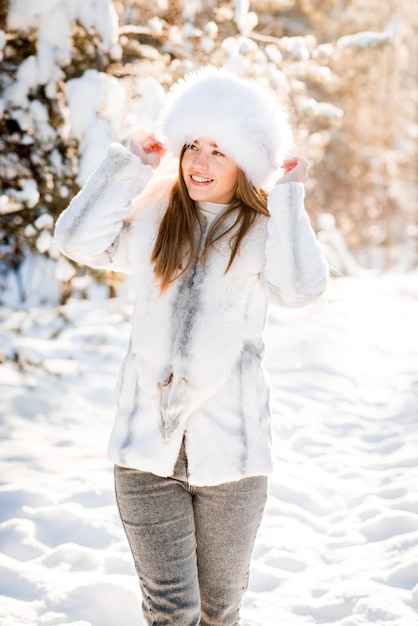 Portrait of young woman in the frosty winter forest