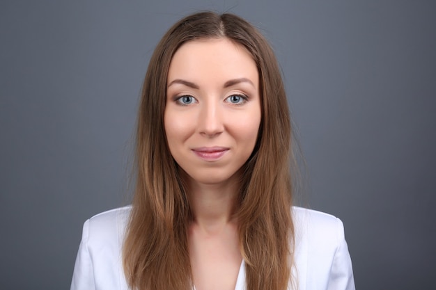 Portrait of young woman on grey wall