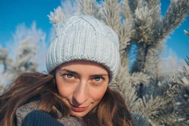 Portrait of young woman in a hat on the snow