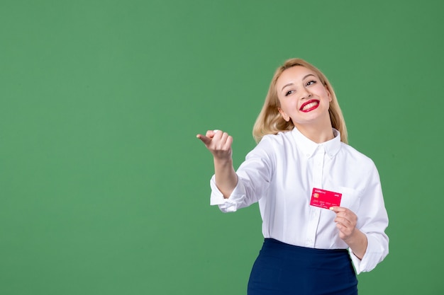 portrait of young woman holding credit card green wall business school teacher money bank