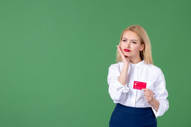 portrait of young woman holding credit card green wall business teacher bank school money