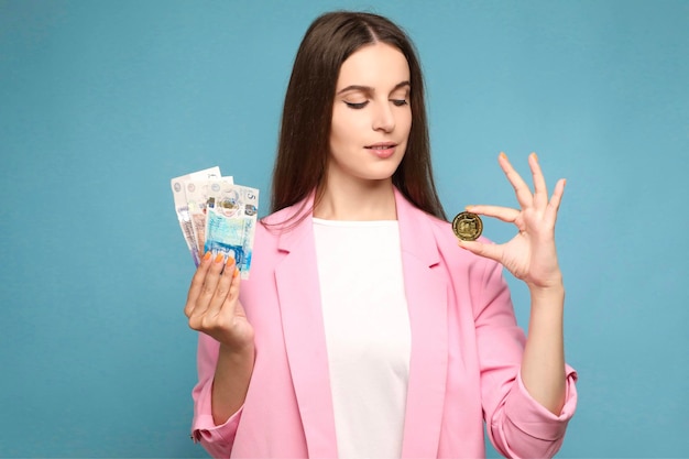 Portrait of young woman holding dogecoin and united kingdom pounds banknotes and looking on dogecoin