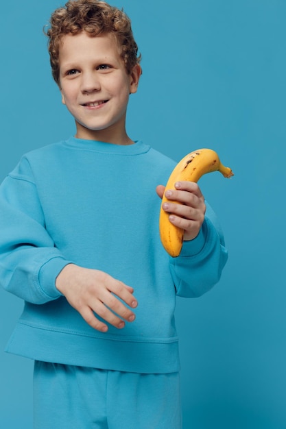 Photo portrait of young woman holding fruit against blue background