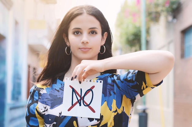 Photo portrait of young woman holding no text on paper in city