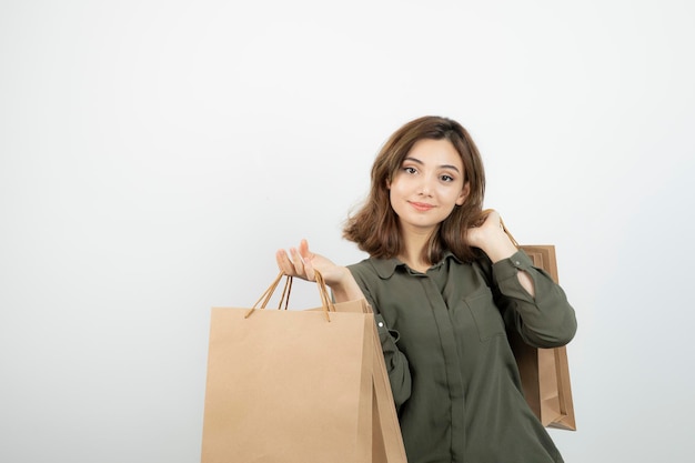 Portrait of young woman holding paper craft bags with happy expression. High quality photo