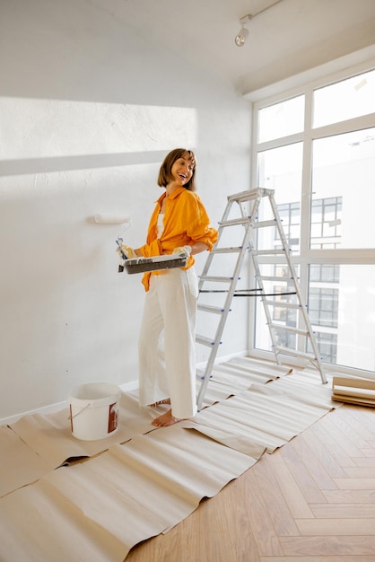 Portrait of a young woman making repairing in apartment