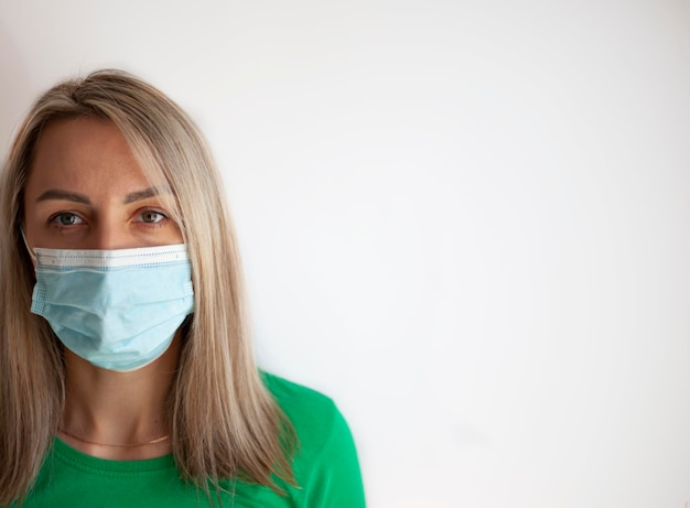 Portrait of a young woman in a medical mask isolated over grey background