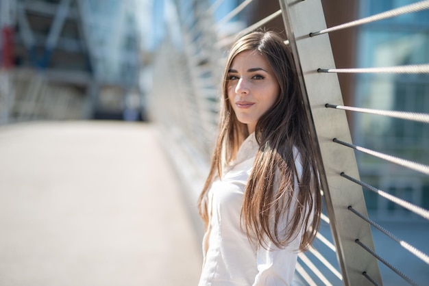 Portrait of a young woman near a bridge