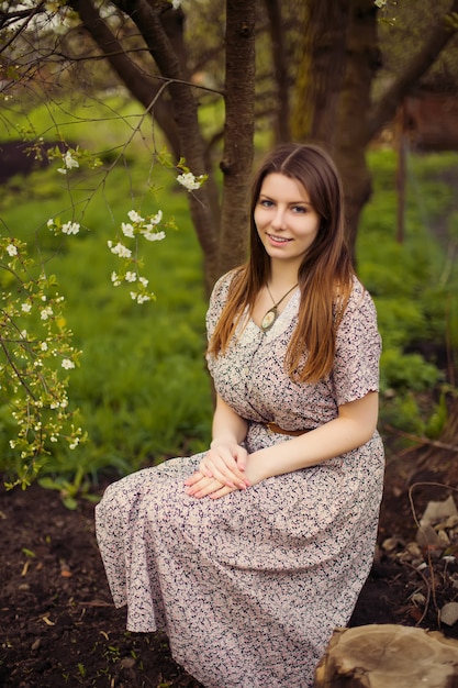 Portrait of young woman in old vintage dress in garden