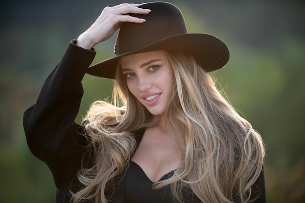 Portrait of young woman outdoor romantic girl in fashion brim black hat with beauty face