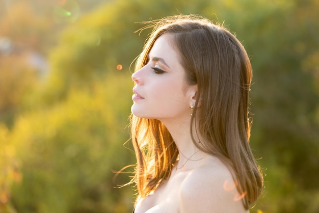 Portrait of young woman outdoor romantic girl with beauty face profile portrait soft sunny light