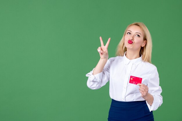 portrait of young woman posing with credit card green wall teacher bank school money business