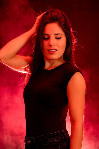 Portrait of a young woman on a red and black background with smoke