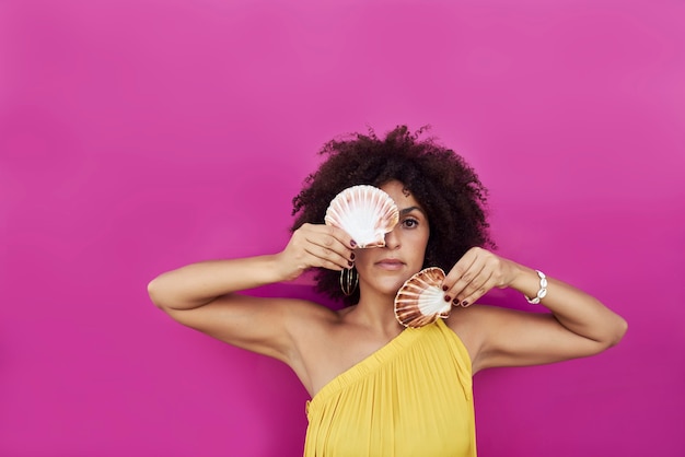 Portrait of a young woman, she is holding a seashell in her hands.