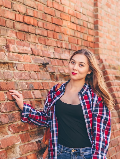 Portrait of young woman in shirt and jeans