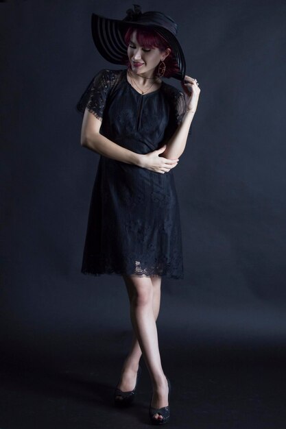 Photo portrait of young woman standing against black background