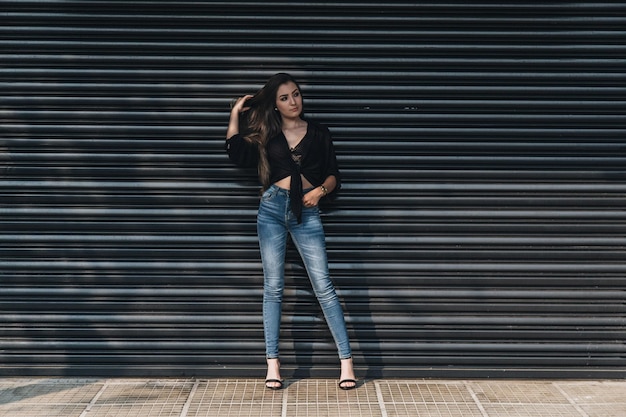 Photo portrait of a young woman standing against brick wall