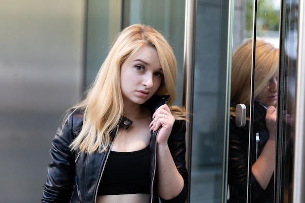 Photo portrait of young woman standing by glass door