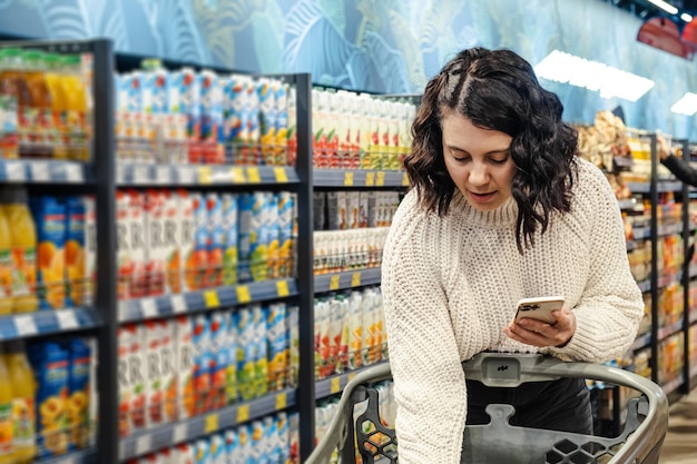 Photo portrait of young woman standing in supermarket