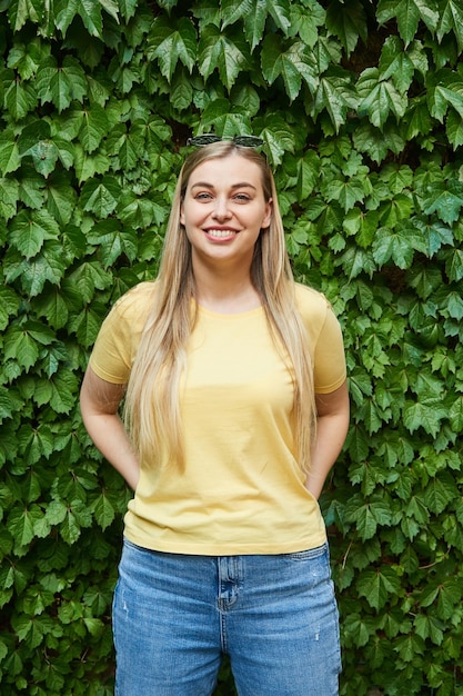 Portrait of a young woman in sunglasses on her head smiling looking at the camera against the backgr