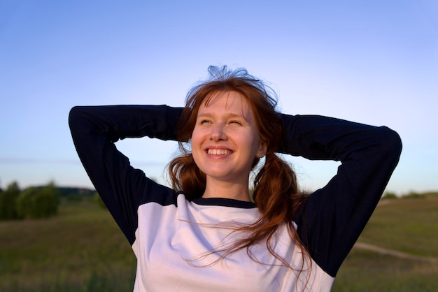 Portrait of young woman teenager girl having fun outdoors at countryside looking at camera and smile