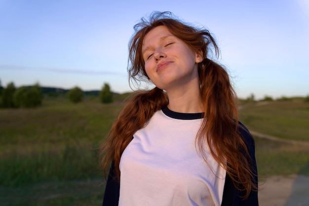 Portrait of young woman teenager girl having fun outdoors at countryside looking at camera and smile