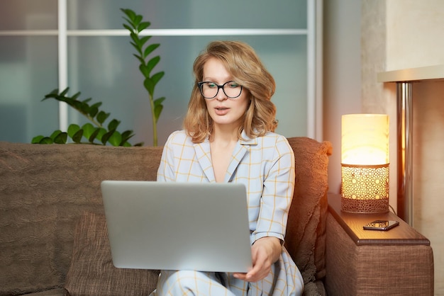 Portrait of young woman using laptop at home