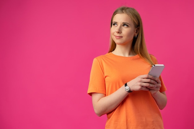 Portrait of a young woman using mobile phone over color background