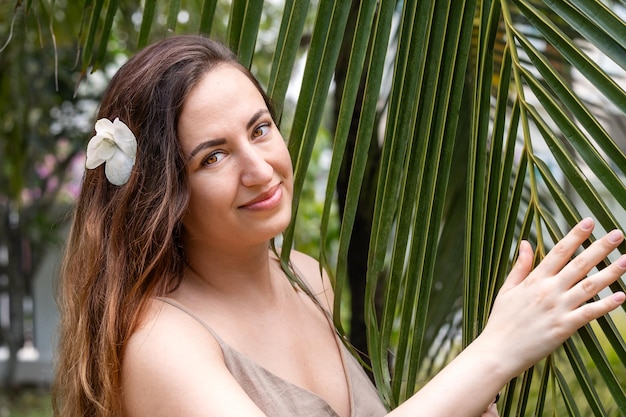 Portrait of a young woman on vacation near a palm tree