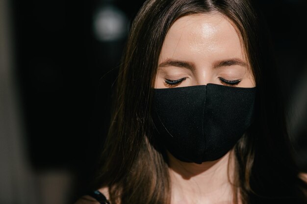 Portrait of young woman wearing black medical mask Protect your health