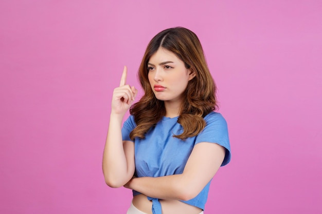 Portrait of young woman wearing casual tshirt thinking and imagination isolated over pink background