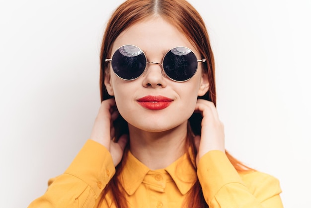 Portrait of young woman wearing sunglasses against white background