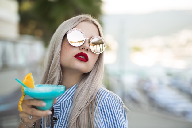 Portrait of a young woman with a cocktail glass at the bar