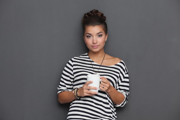 Portrait of young woman with cup tea or coffee