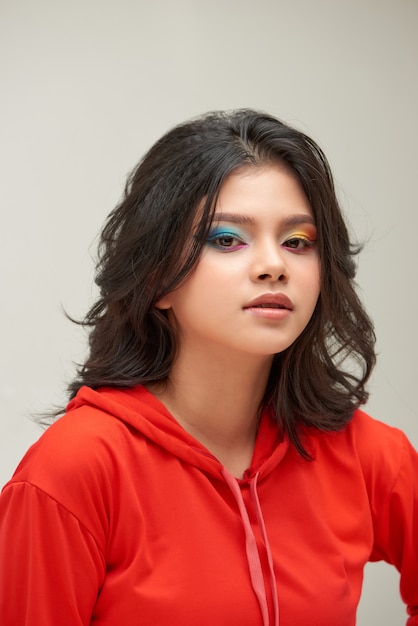 Portrait of young woman with funny rainbow colored make-up