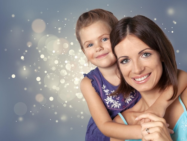 Portrait of young woman with little girl on background