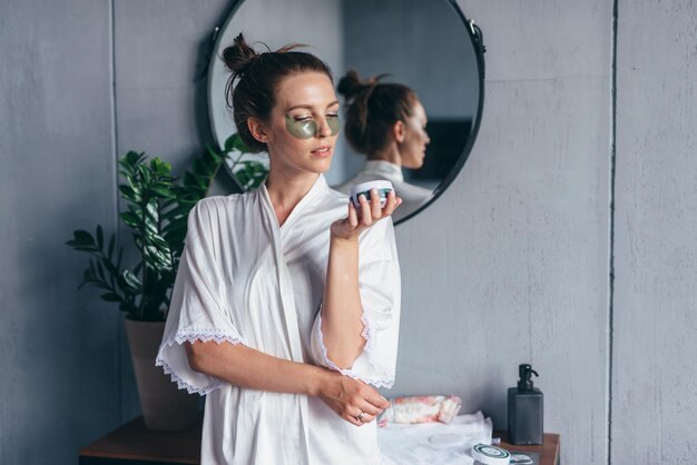 Portrait of a young woman with patches under her eyes in the bathroom