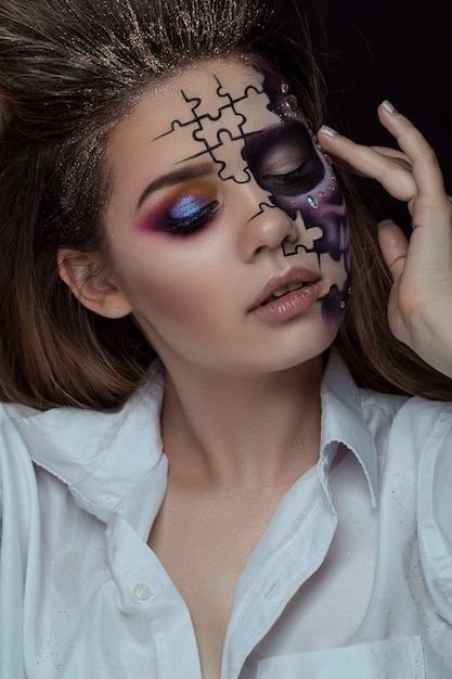 Portrait of young woman with scared halloween makeup over black