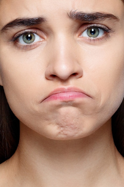 Portrait of young woman with shocked expression of sadness