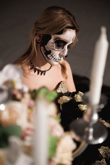 Portrait of zombie woman with painted skull face