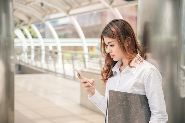 Portraits of beautiful asian woman look confidence is holding cellphone